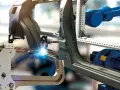 Roboty spawalnicze pracują nad elementami karoserii, tworząc precyzyjne połączenia. To przykład zaawansowanych systemów MRP w akcji.