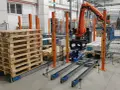 Nowoczesne systemy paletyzacji: robot KUKA układa paczki na palecie na linii produkcyjnej.