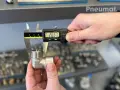 Precyzyjne pomiary gwintów zewnętrznych kolanka pneumatycznego suwmiarką cyfrową. Wynik 26.57 mm.