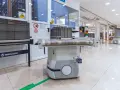Nowoczesny agv robot z taśmociągiem w magazynie, gotowy do transportu towarów.