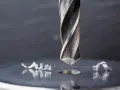 Metalowe wióry wokół świeżo wywierconego otworu świadczą o sile i precyzji najtwardszych wierteł do metalu.