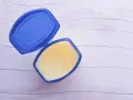 Otwarty pojemnik z wazeliną techniczną, idealną do smarowania i ochrony.