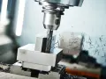Frezarka CNC obrabia metal, tworząc wióry. Różne rodzaje frezarek pozwalają na precyzyjne kształtowanie detali.