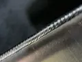 Precyzyjne spawanie aluminium, widoczny ścieg spawalniczy o regularnych falach.