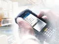 Ręczne skanowanie za pomocą terminala mobilnego, pokazujące zastosowanie RFID w magazynie do śledzenia kontenerów i zarządzania zadaniami.