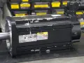 Silnik elektryczny Rexroth z hamulcem, gotowy do pracy. W tle widać półki z częściami.