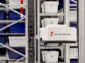 Automatyczny wózek w magazynie LPP Logistics pobiera pojemniki. System psi wms usprawnia pracę.
