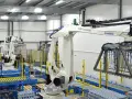 Nowoczesny magazyn automatyczny z robotami przemysłowymi. Taśmociągi i palety z produktami.