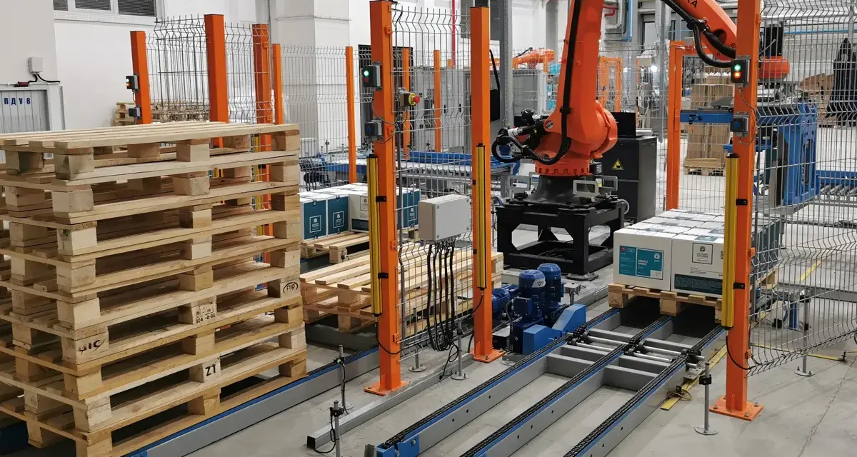 Nowoczesne systemy paletyzacji: robot KUKA układa paczki na palecie na linii produkcyjnej.