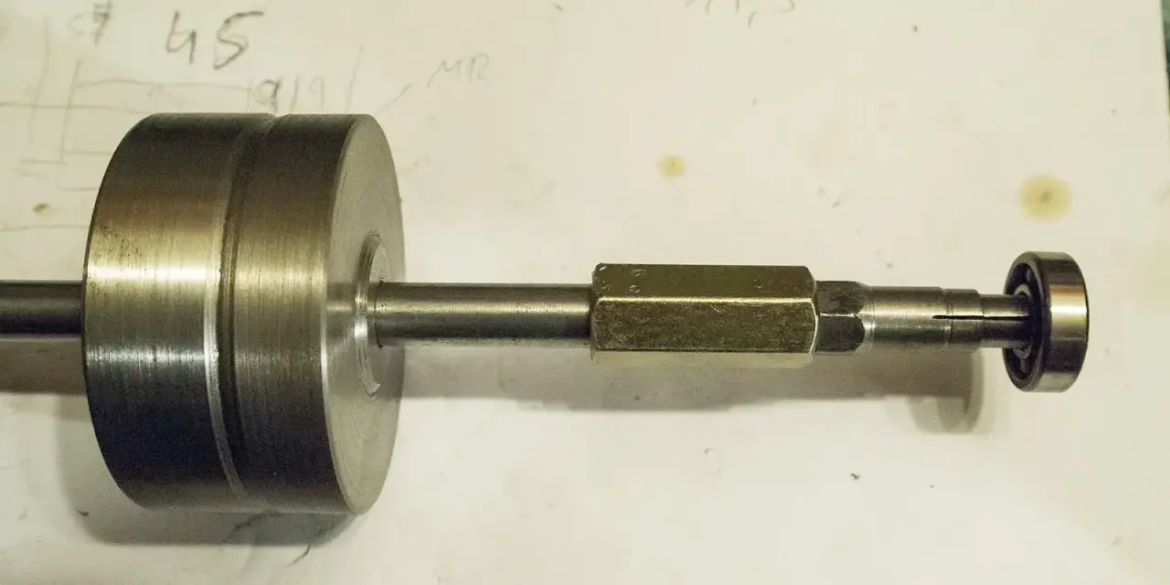 Domowy sposób na to, jak ściągnąć łożysko bez ściągacza. Metalowy element z łożyskiem na końcu.
