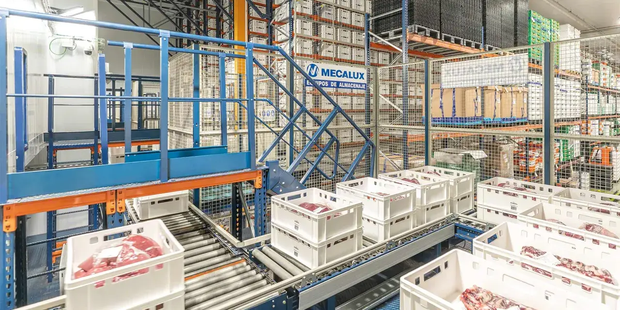 Automatyczny magazyn mięsa, gdzie białe skrzynki z produktami przemieszczają się po taśmociągu, zgodnie z zasadą FEFO.