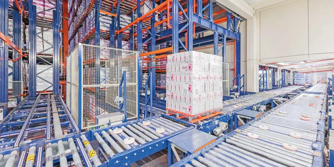 Automatyczne magazyny z zaawansowanymi systemami transportu bliskiego. Palety z produktami przemieszczają się po taśmociągach w hali.