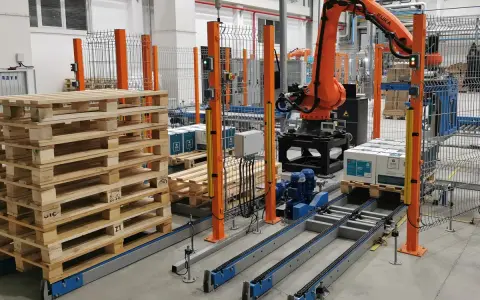 Nowoczesne systemy paletyzacji: robot KUKA układa paczki na palecie na linii produkcyjnej.