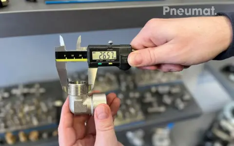 Precyzyjne pomiary gwintów zewnętrznych kolanka pneumatycznego suwmiarką cyfrową. Wynik 26.57 mm.