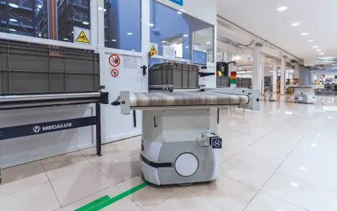 Nowoczesny agv robot z taśmociągiem w magazynie, gotowy do transportu towarów.