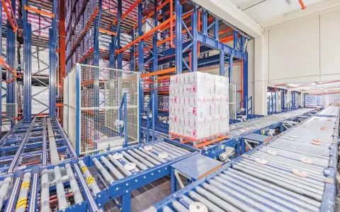 Automatyczne magazyny z zaawansowanymi systemami transportu bliskiego. Palety z produktami przemieszczają się po taśmociągach w hali.