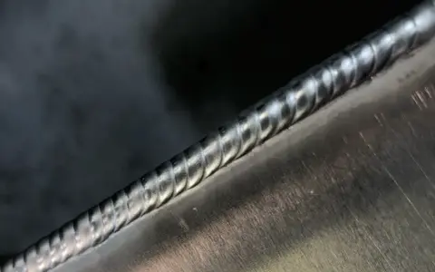 Precyzyjne spawanie aluminium, widoczny ścieg spawalniczy o regularnych falach.
