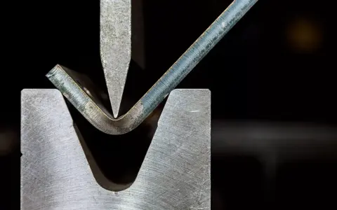 Precyzyjna obróbka plastyczna metali: gięcie blachy pod naciskiem stempla.
