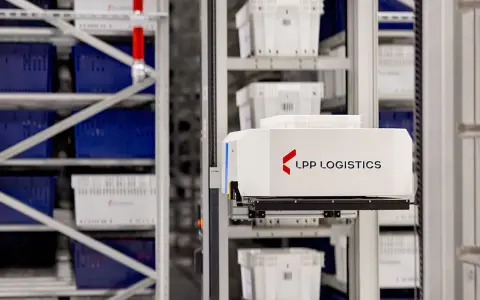 Automatyczny wózek w magazynie LPP Logistics pobiera pojemniki. System psi wms usprawnia pracę.