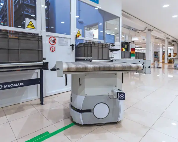 Nowoczesny agv robot z taśmociągiem w magazynie, gotowy do transportu towarów.