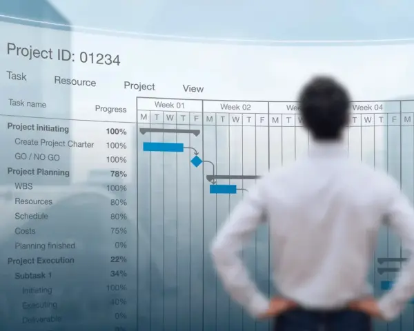 Mężczyzna analizuje wykres Gantta dla projektu aps. Widać postęp prac, zadania i harmonogram.