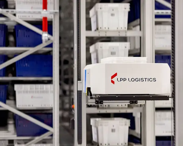 Automatyczny wózek w magazynie LPP Logistics pobiera pojemniki. System psi wms usprawnia pracę.