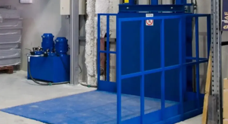 Niebieska winda magazynowa z hydraulicznym podnośnikiem ułatwia transport towarów.