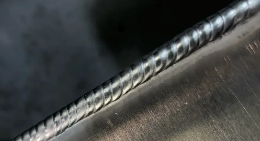 Precyzyjne spawanie aluminium, widoczny ścieg spawalniczy o regularnych falach.