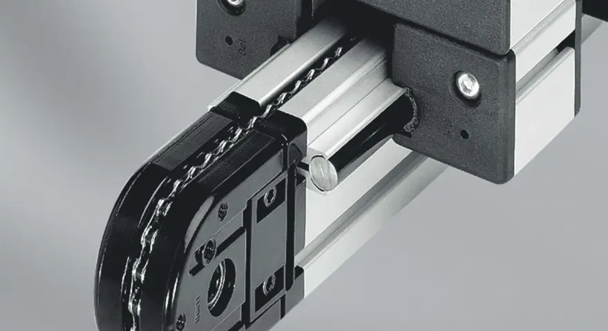 Mechanizm z łańcuchem i rolkami, część precyzyjnych przekładni łańcuchowych, porusza się po aluminiowej szynie.