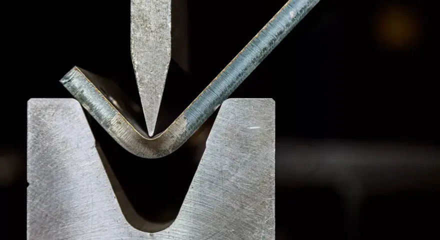 Precyzyjna obróbka plastyczna metali: gięcie blachy pod naciskiem stempla.