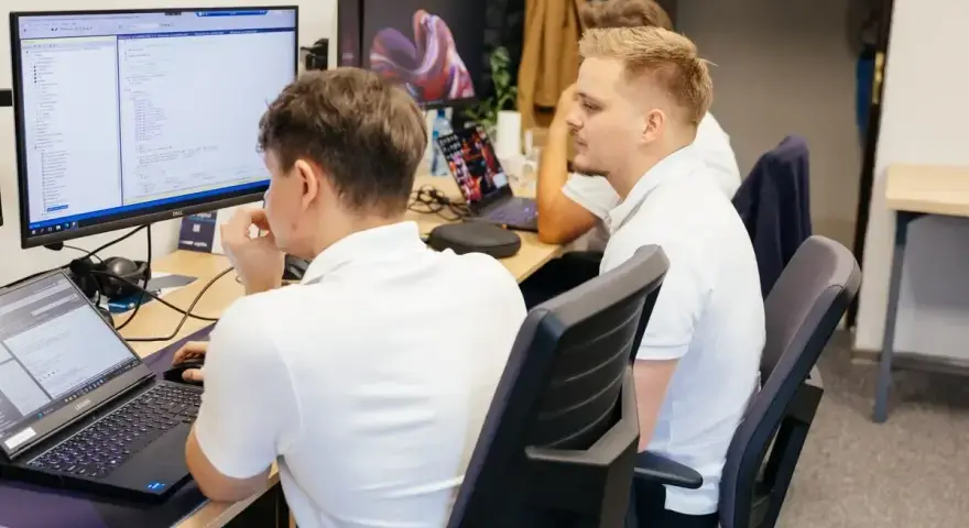 Programiści pracują nad kodem, analizując dane i rozwiązując queris cmms.
