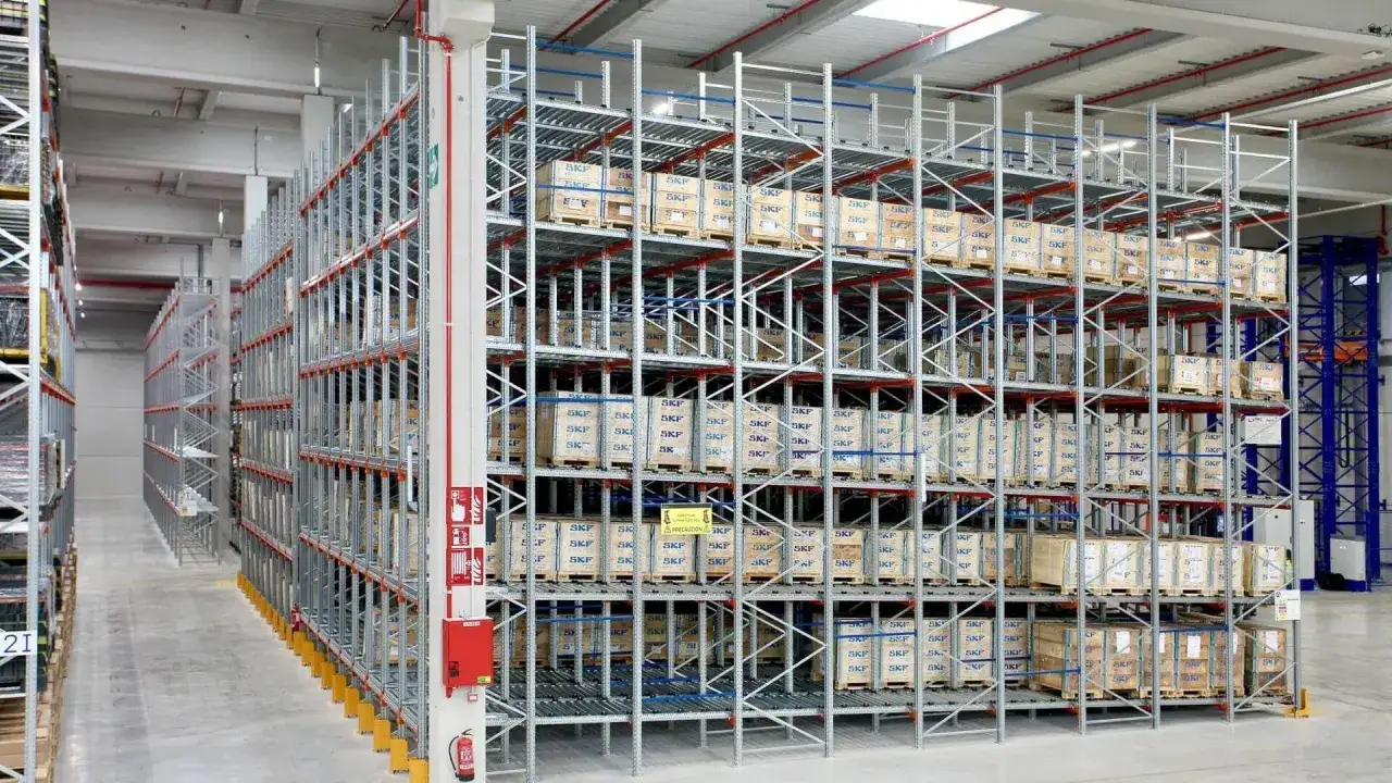 Duży magazyn z systemem flow rack, wypełniony paletami z produktami SKF.