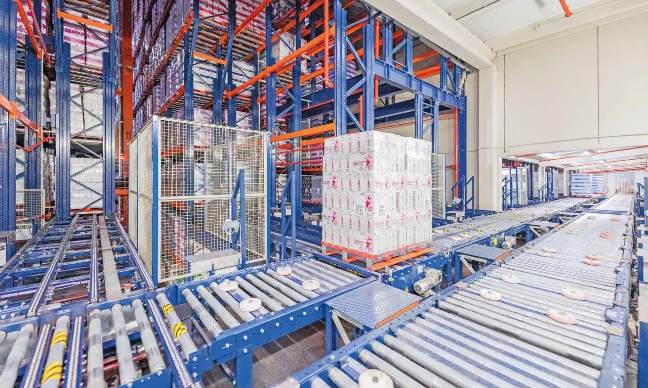 Automatyczne systemy transportu wewnętrznego w magazynie wysokiego składowania. Paleta z produktami na taśmie transportowej.