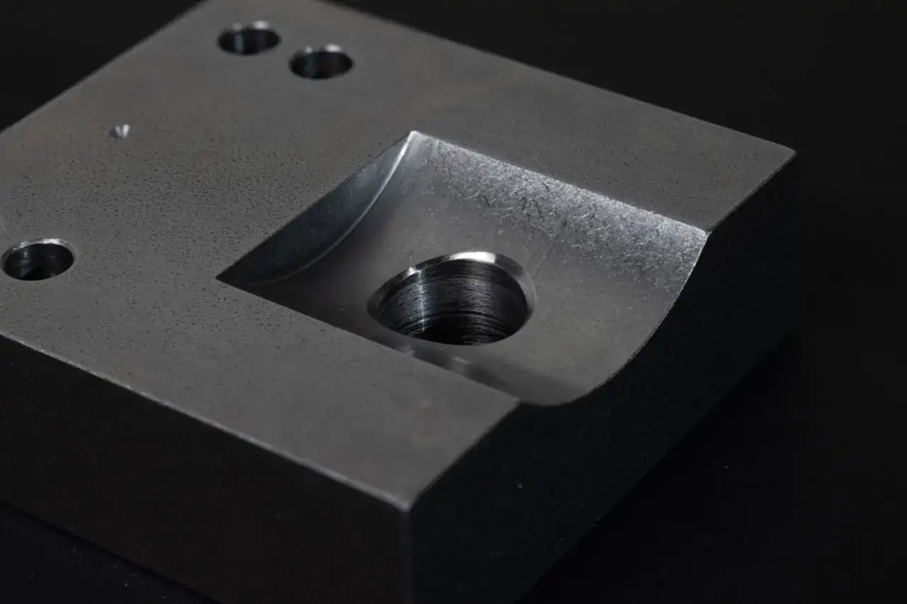 Metalowy element z precyzyjnie wykonanym gwintowanym otworem, świadczącym o starannym gratowaniu otworów.